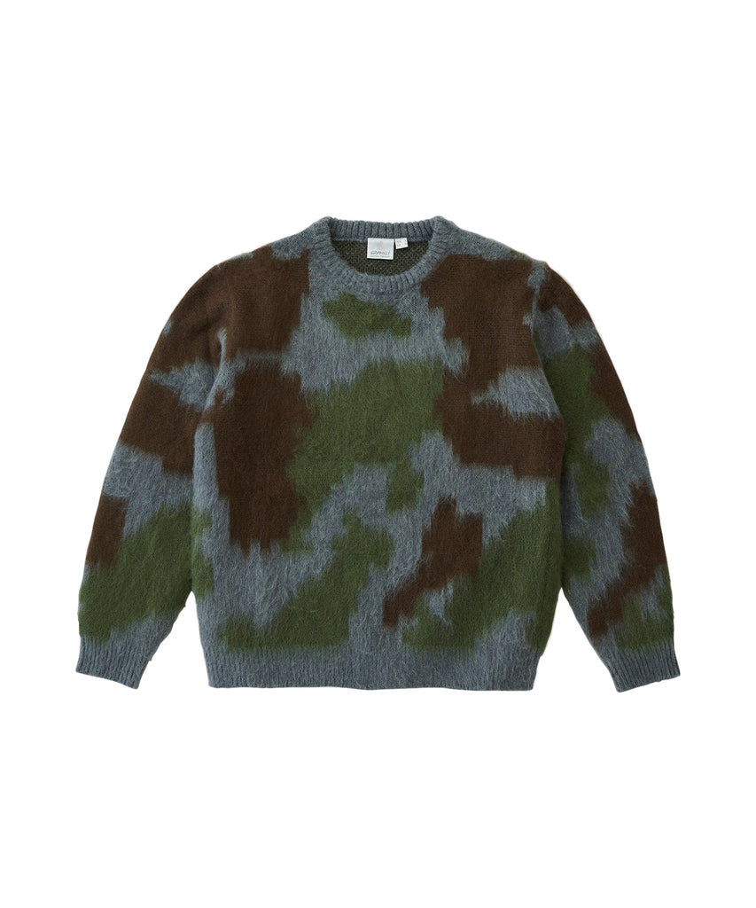Camouflage-patterned sweater on a light gray background